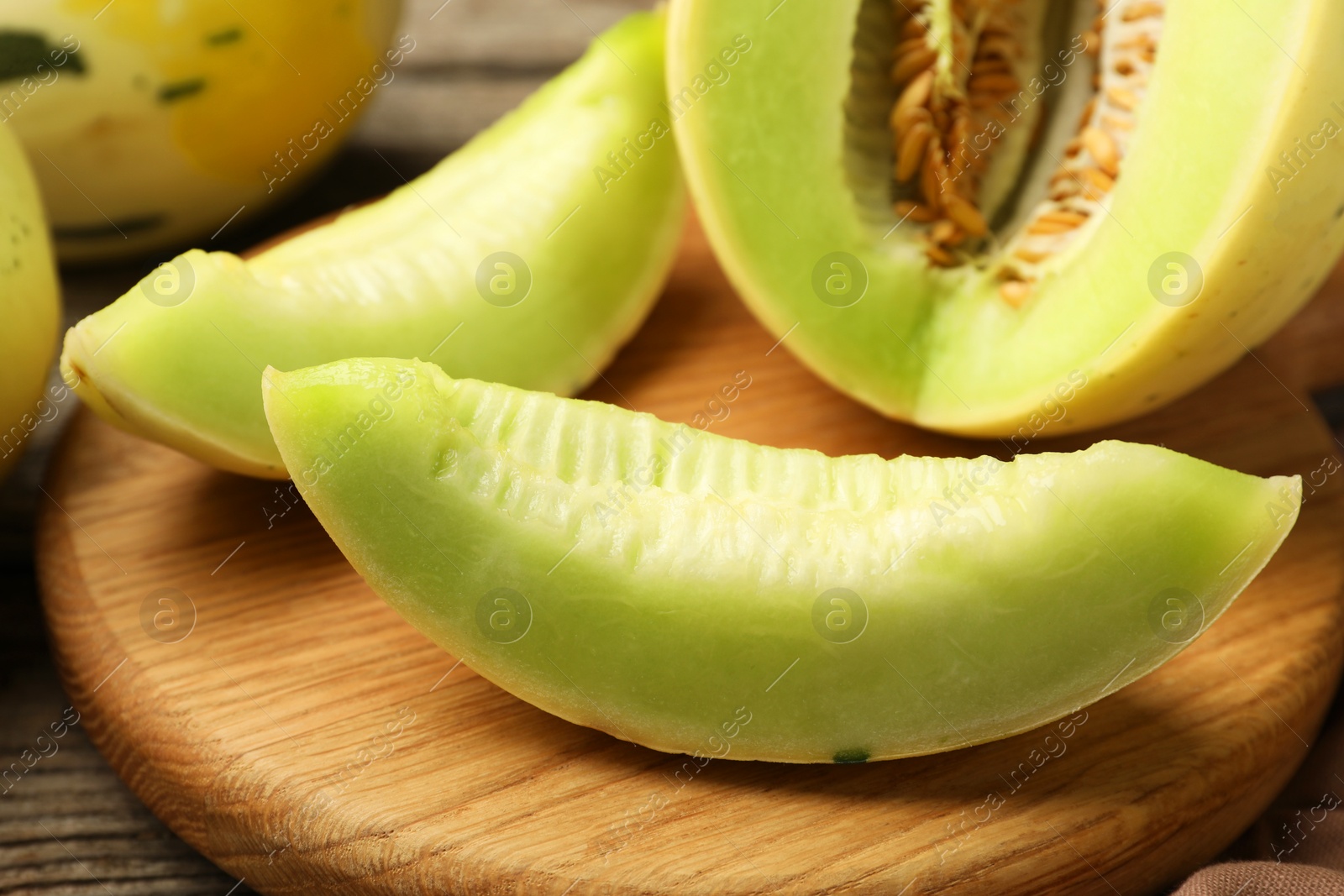 Photo of Fresh cut honeydew melon on wooden table, closeup