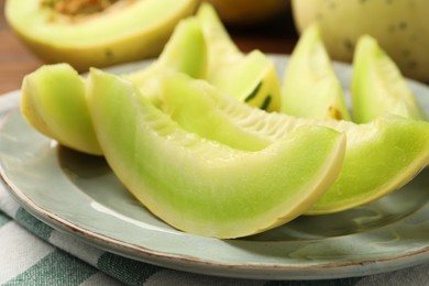 Photo of Plate with pieces of honeydew melon on table, closeup