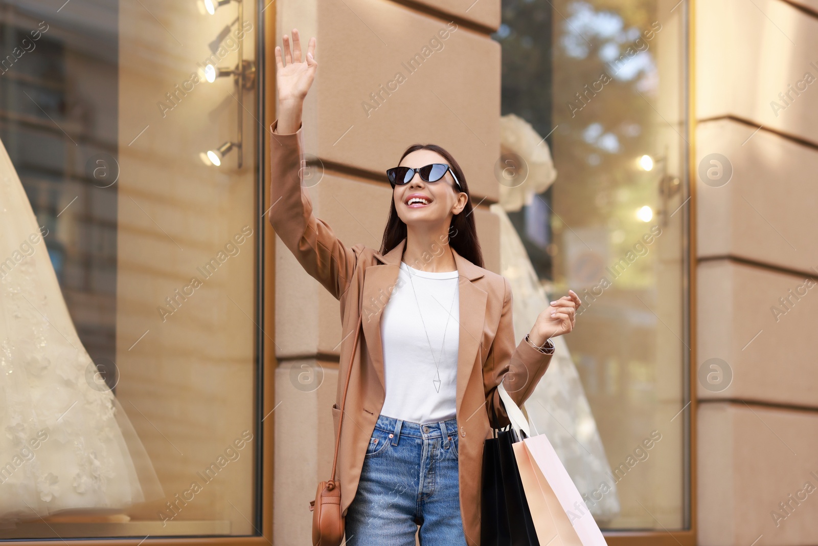 Photo of Happy woman with many shopping bags outdoors