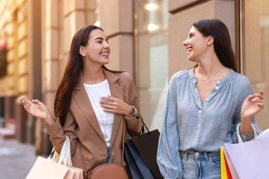 Happy women with colorful shopping bags outdoors