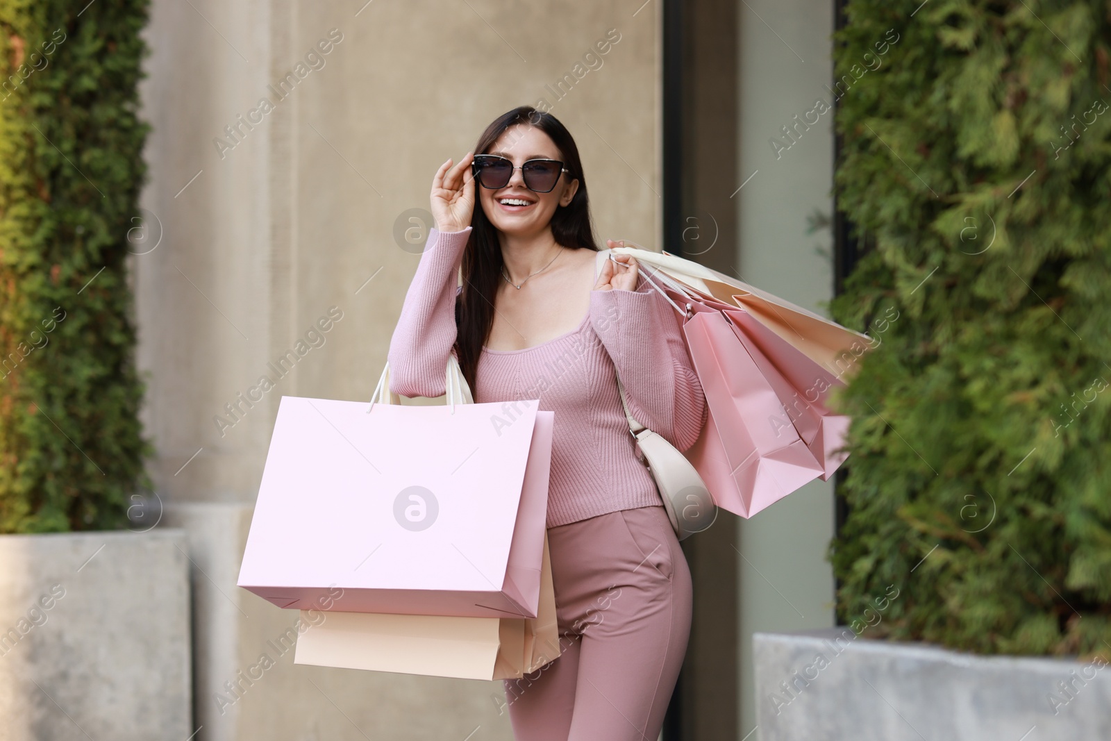 Photo of Happy woman with colorful shopping bags outdoors