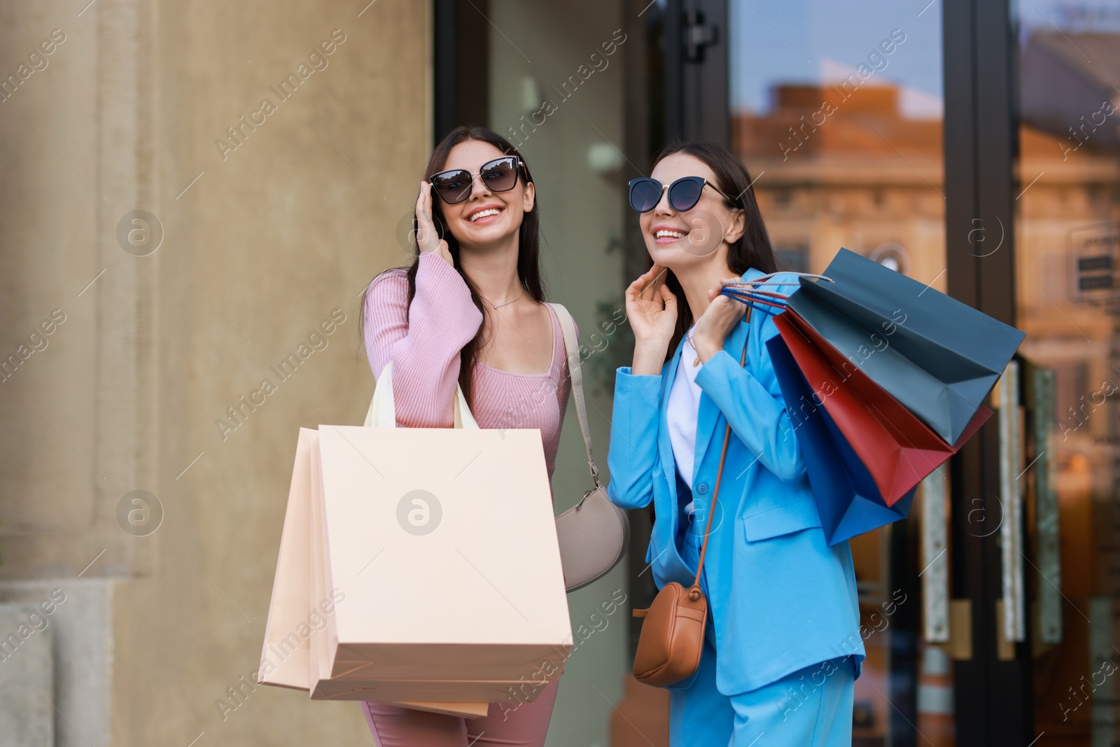 Photo of Happy women with colorful shopping bags outdoors