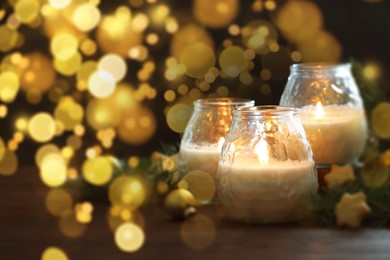 Image of Christmas composition with burning candles on wooden table, bokeh effect. Festive card