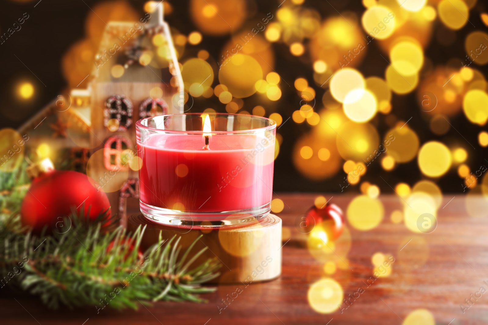 Image of Christmas composition with burning candle on wooden table, bokeh effect. Festive card