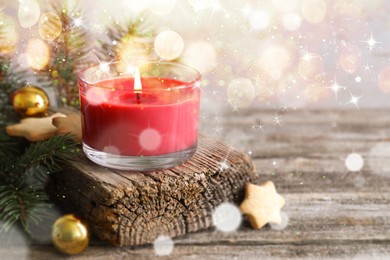 Image of Christmas composition with burning candle on wooden table, bokeh effect. Festive card