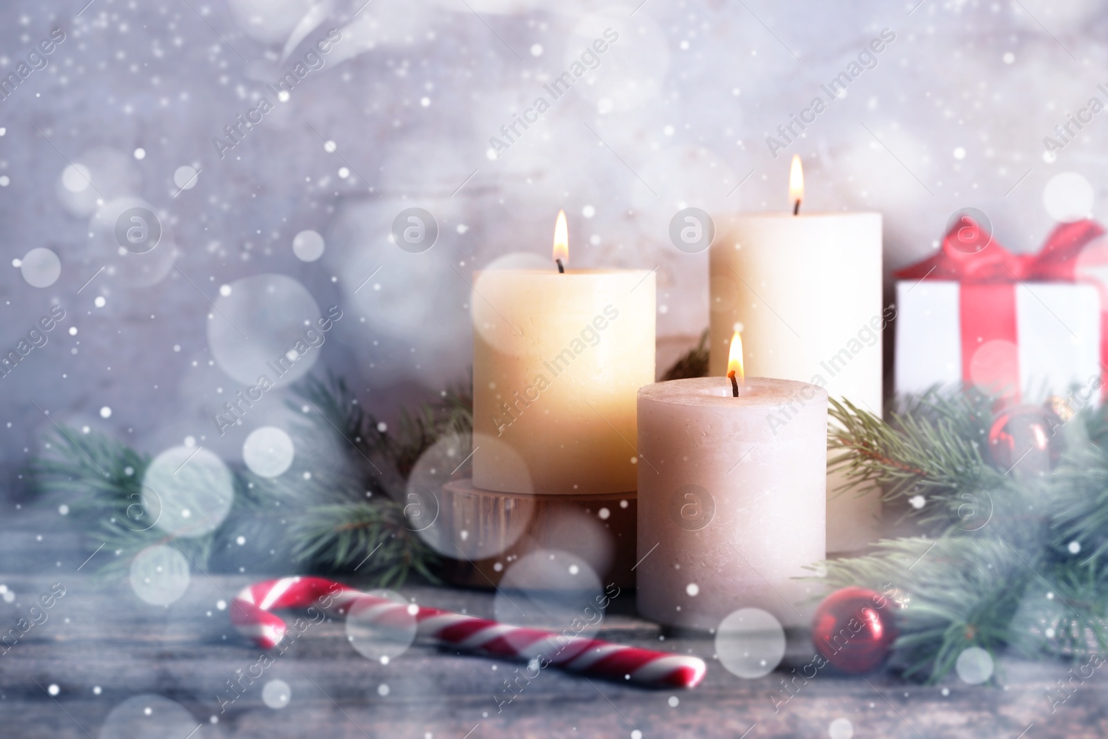 Image of Christmas composition with burning candles on wooden table, bokeh effect. Festive card