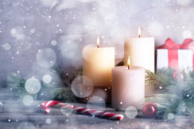 Image of Christmas composition with burning candles on wooden table, bokeh effect. Festive card