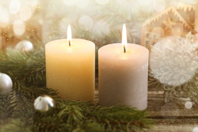 Image of Christmas composition with burning candles on wooden table, bokeh effect. Festive card