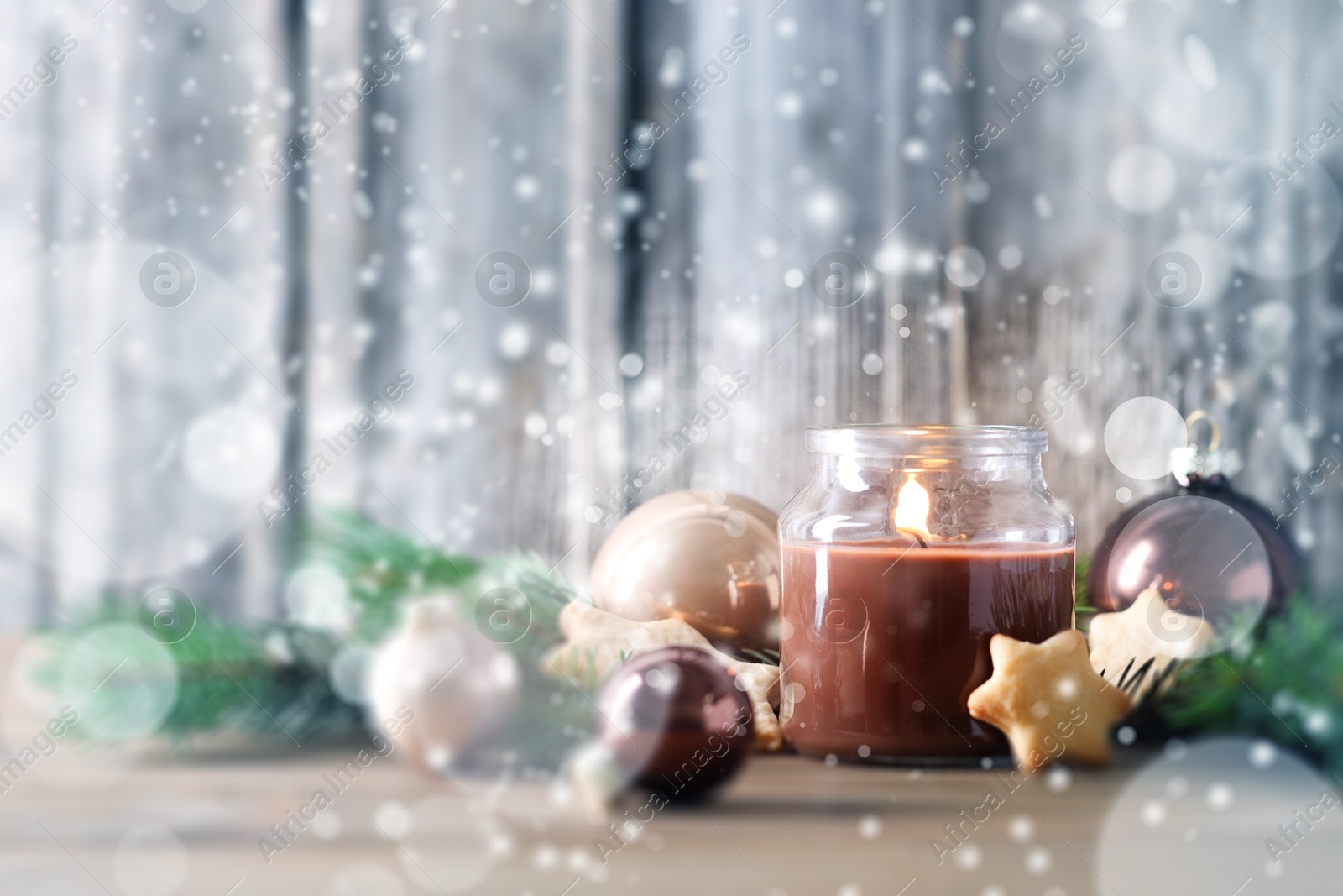 Image of Christmas composition with burning candle on wooden table, bokeh effect. Festive card