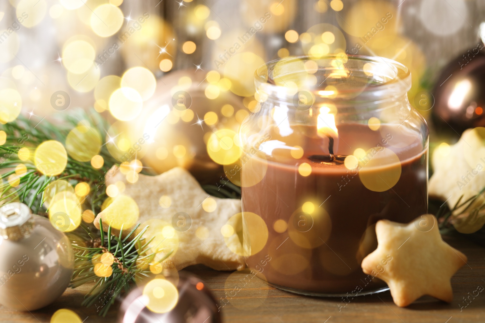 Image of Christmas composition with burning candle on wooden table, bokeh effect. Festive card