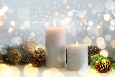 Image of Christmas composition with burning candles on white table, bokeh effect. Festive card