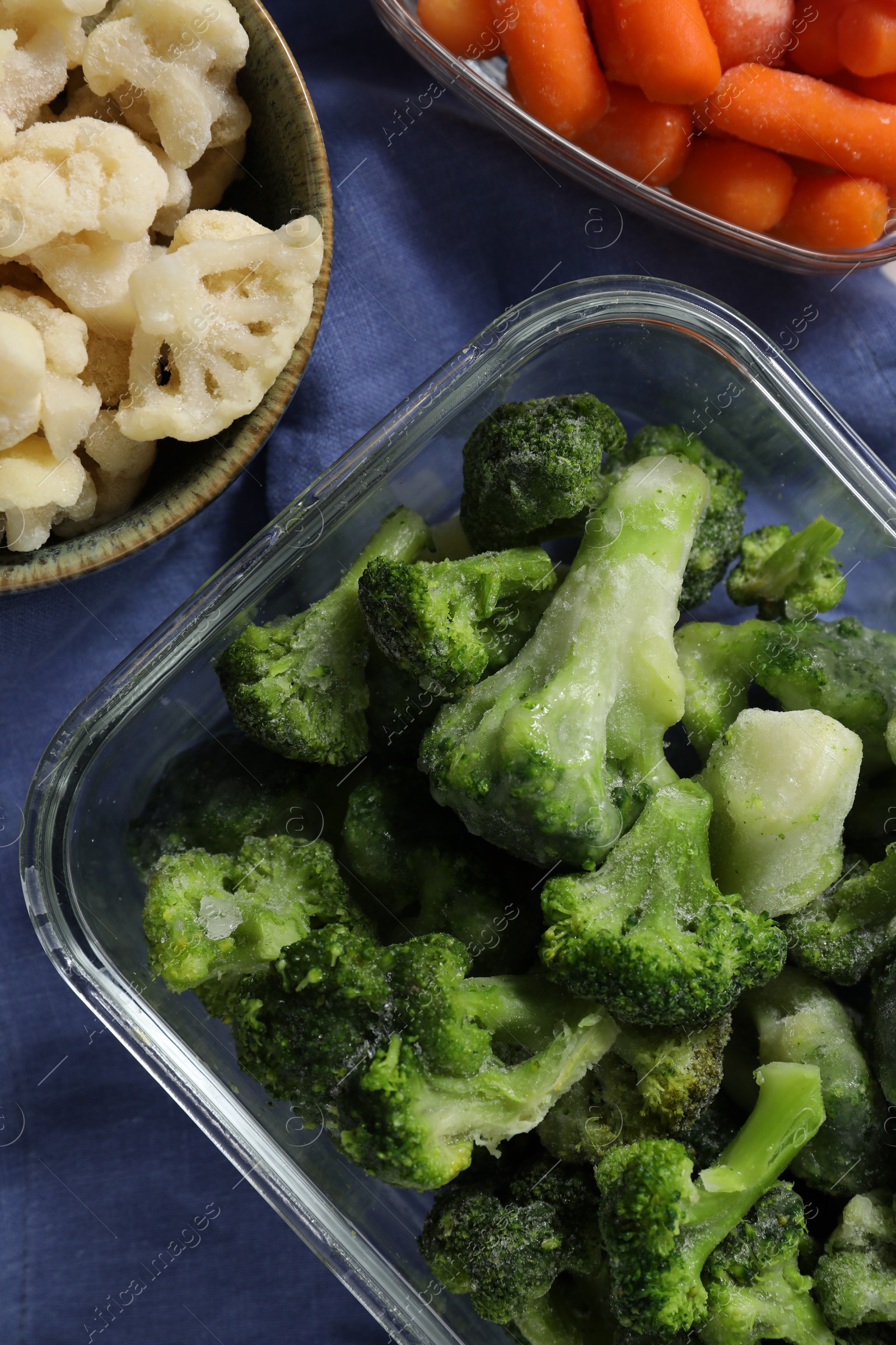 Photo of Frozen broccoli, cauliflower and baby carrots on table, top view