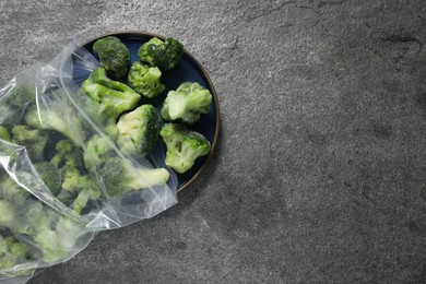 Photo of Frozen broccoli out of plastic bag on grey table, top view. Space for text