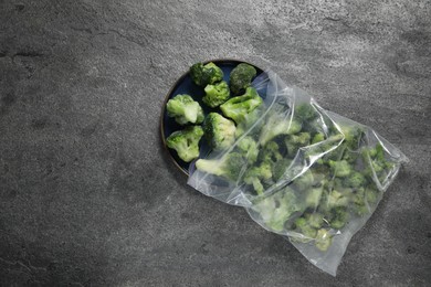 Photo of Frozen broccoli out of plastic bag on grey table, top view. Space for text