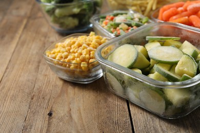 Photo of Different frozen vegetables on wooden table, closeup