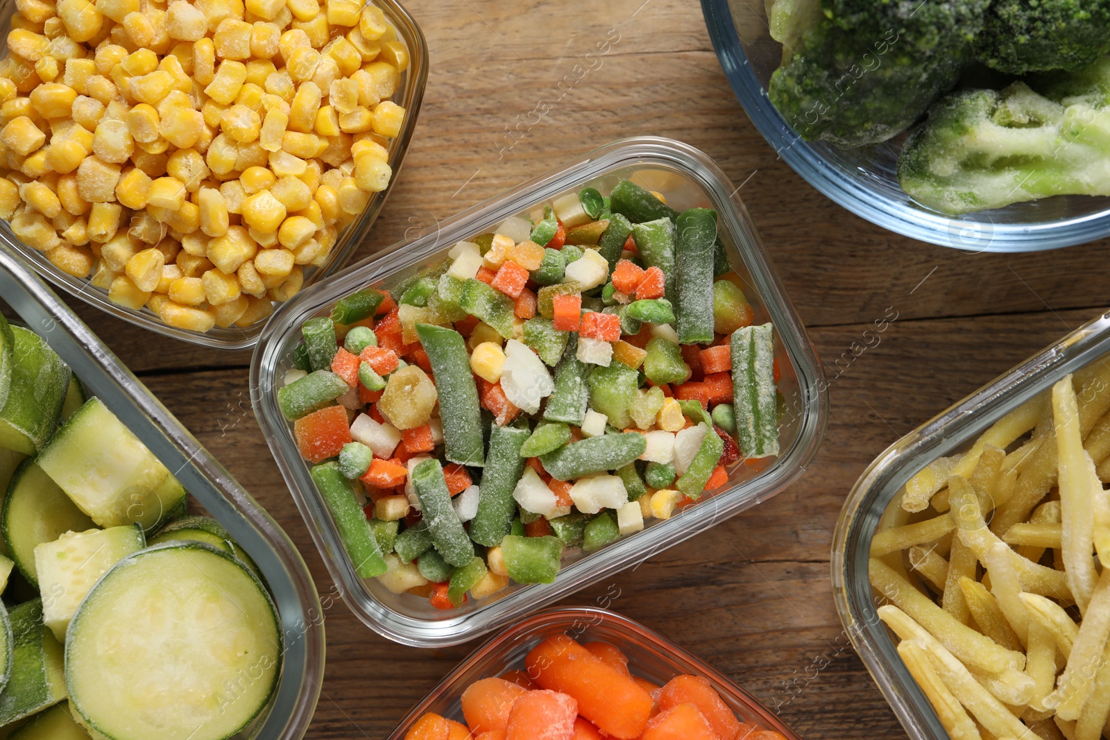 Photo of Different frozen vegetables on wooden table, flat lay