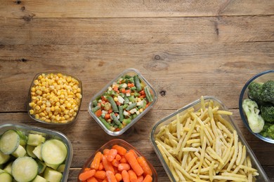 Photo of Different frozen vegetables on wooden table, flat lay