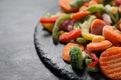 Photo of Mix of frozen vegetables on black table, closeup