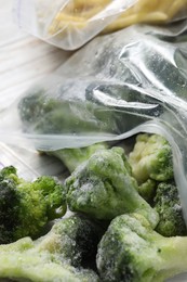 Photo of Frozen broccoli out of plastic bag on table, closeup