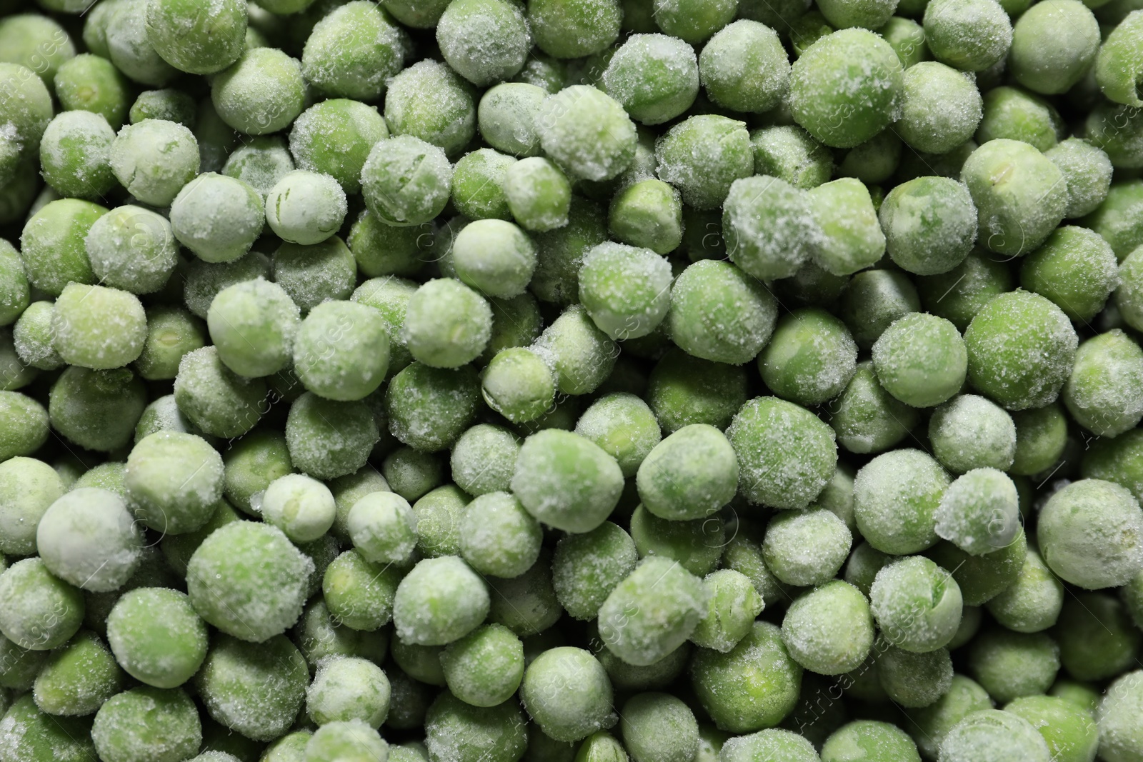 Photo of Frozen green peas as background, top view