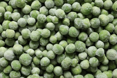 Photo of Frozen green peas as background, top view