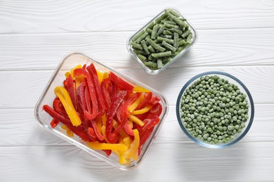 Photo of Frozen green beans, peas and bell peppers on white wooden table, top view