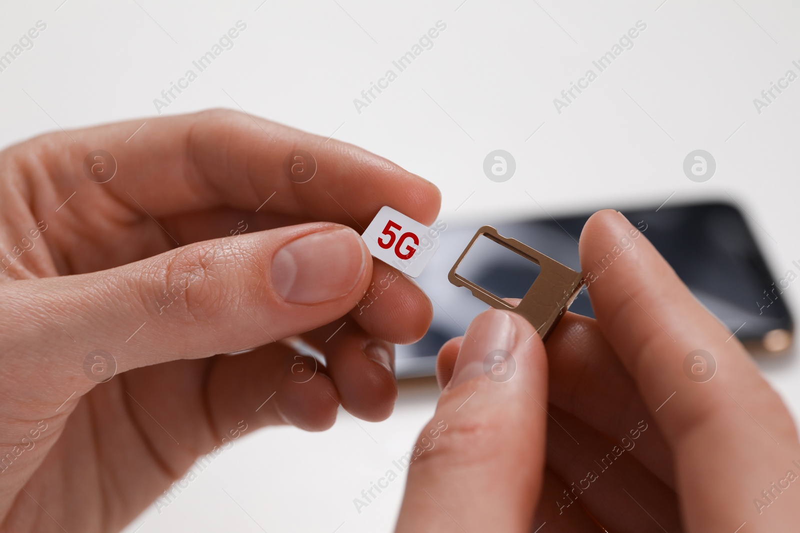 Image of Woman with 5G SIM card and slot tray on white background, closeup