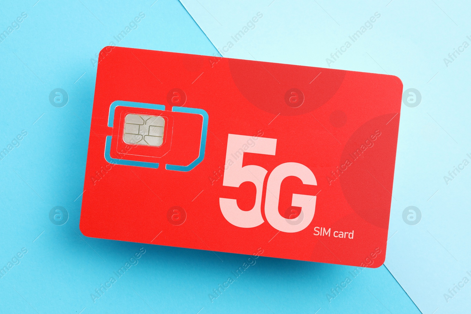 Image of Red 5G SIM card on light blue background, top view