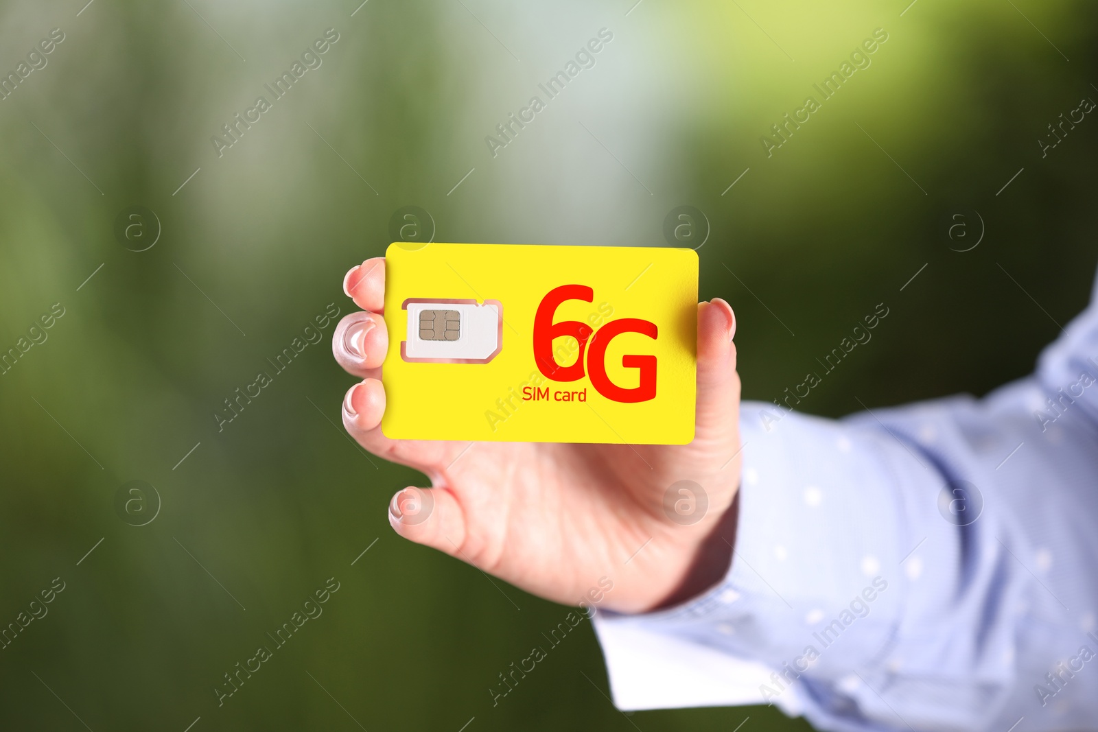 Image of Woman holding 6G SIM card on blurred background, closeup