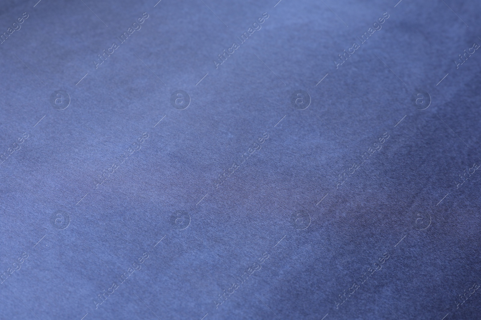 Photo of Texture of dark blue silk fabric as background, closeup