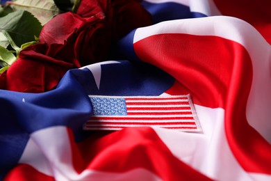 Photo of Veterans day. USA army patch and rose flowers on American flag