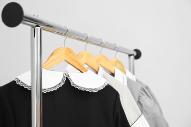 Photo of Maids' uniforms on clothing rack against grey background, closeup