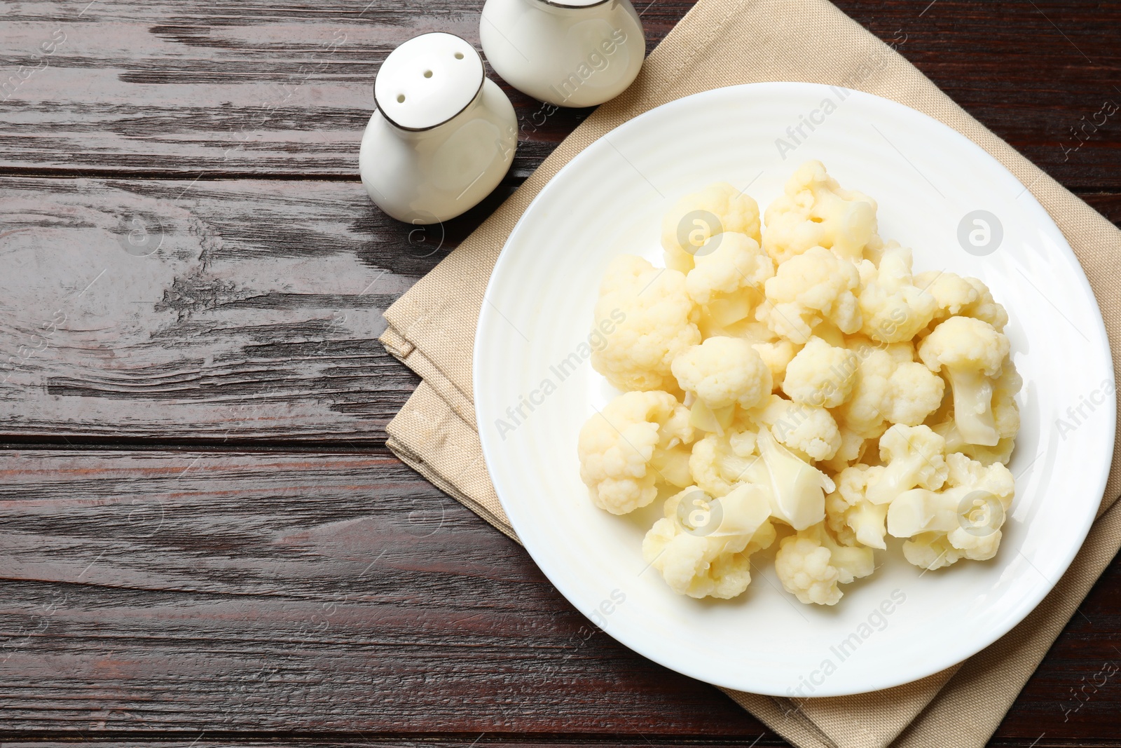 Photo of Tasty cooked cauliflower on wooden table, top view. Space for text