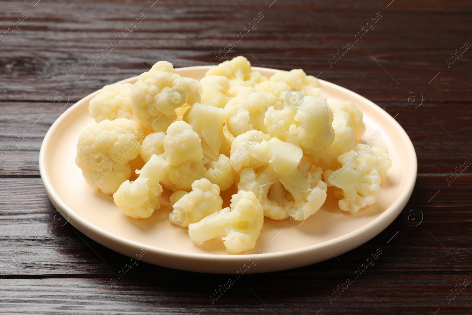 Photo of Tasty cooked cauliflower on wooden table, closeup