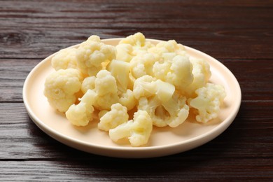 Photo of Tasty cooked cauliflower on wooden table, closeup