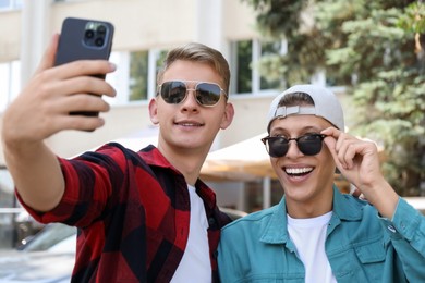 Happy brothers taking selfie on city street