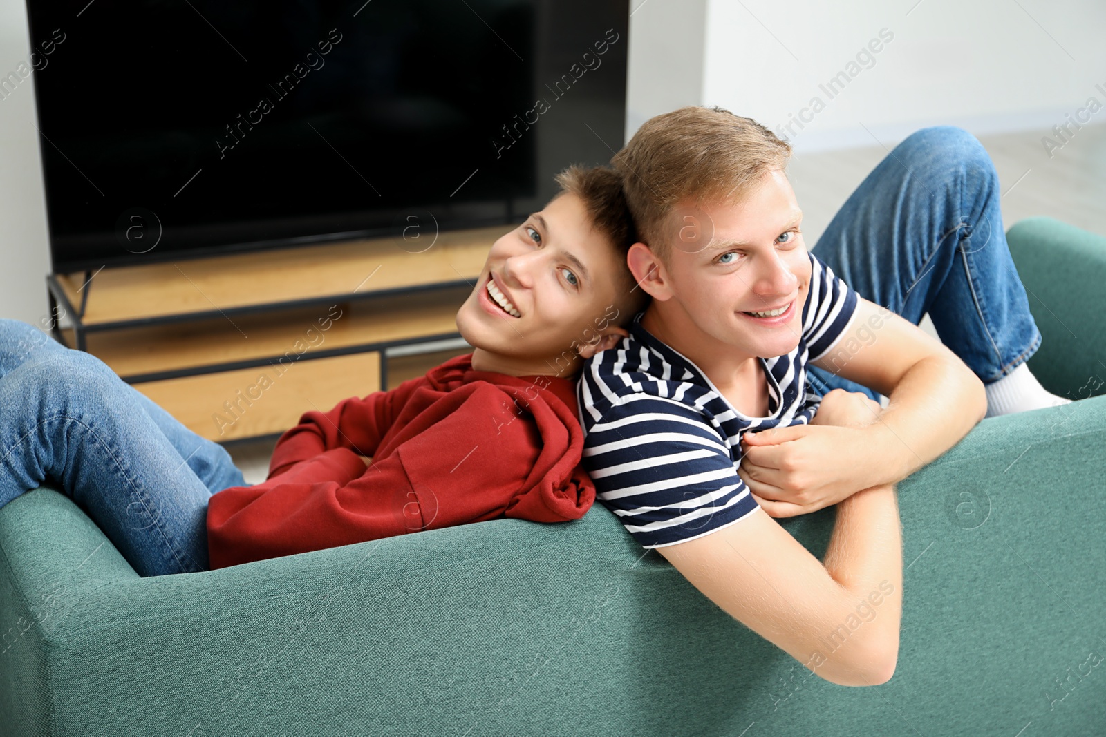 Photo of Family portrait of happy brothers on sofa at home