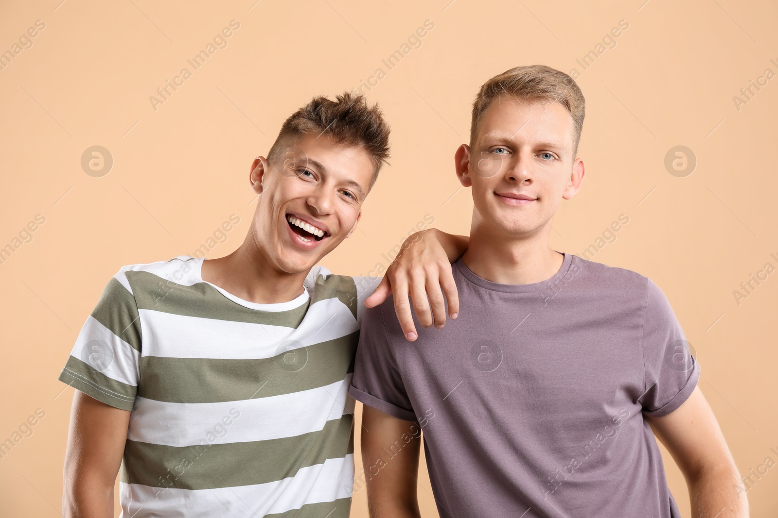 Photo of Portrait of happy brothers on beige background