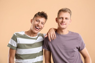 Portrait of happy brothers on beige background