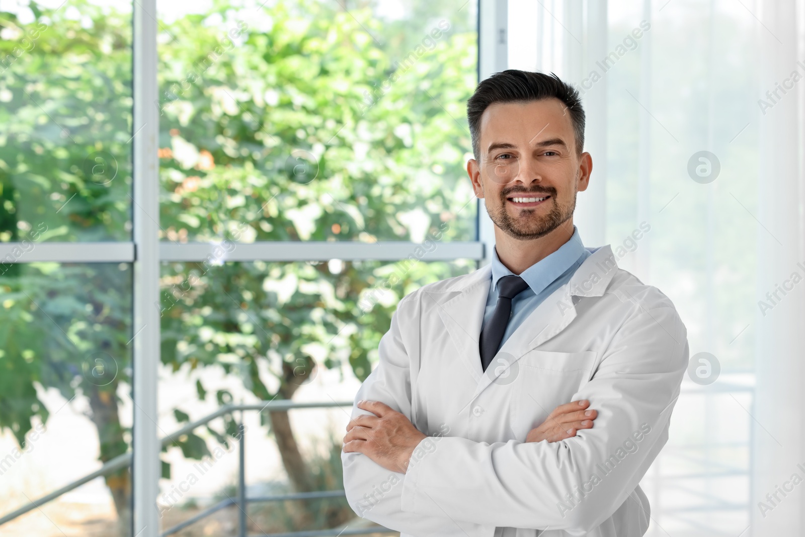 Photo of Portrait of smiling doctor indoors, space for text