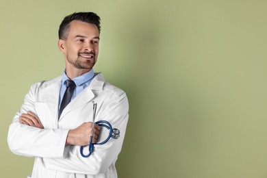 Photo of Smiling doctor with stethoscope on olive background. Space for text