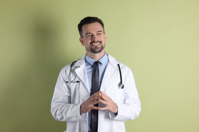 Smiling doctor with stethoscope on olive background