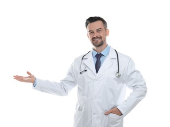 Photo of Smiling doctor with stethoscope pointing at something on white background