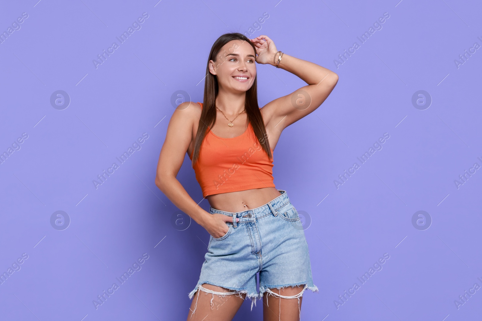 Photo of Beautiful woman wearing stylish denim shorts on violet background