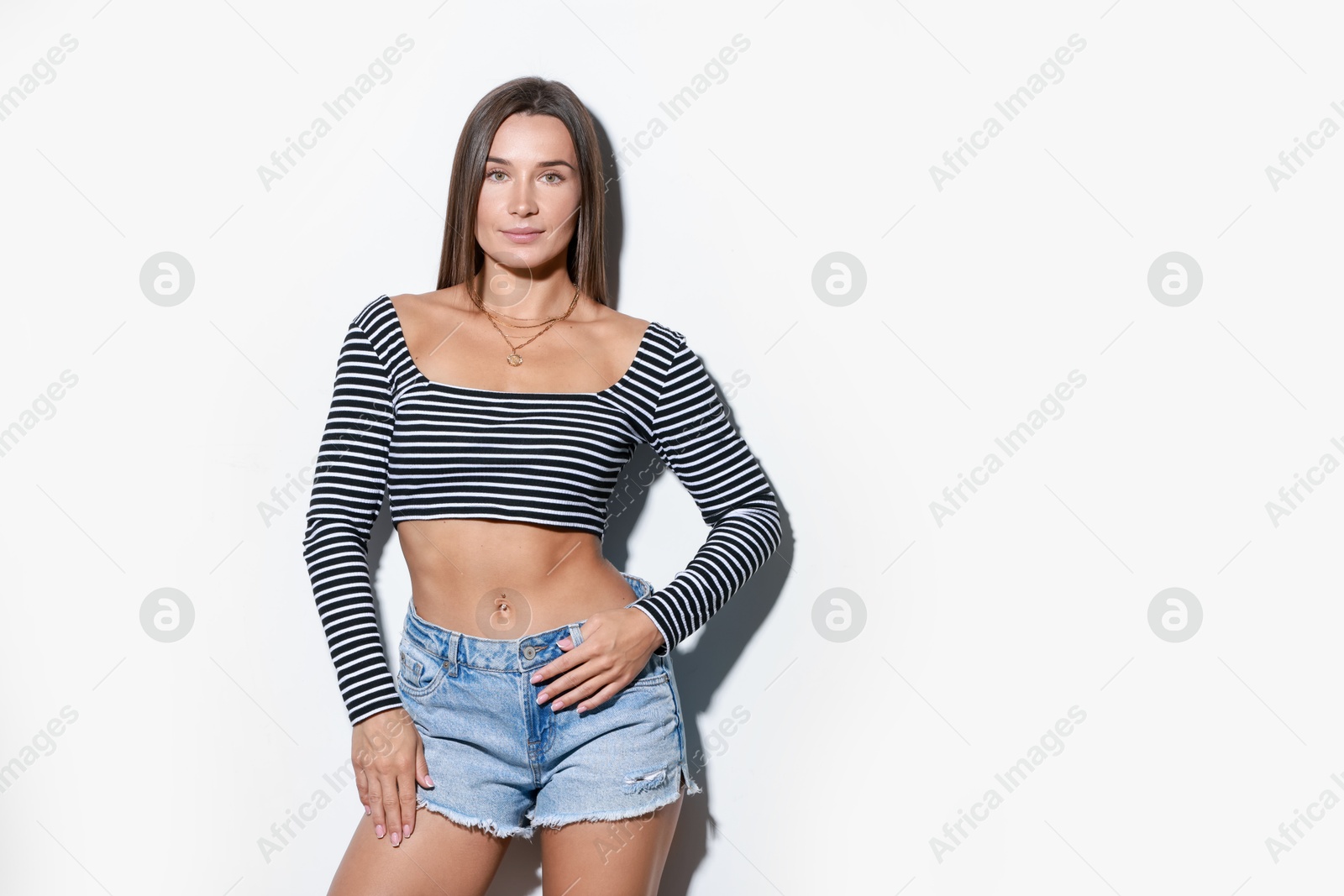 Photo of Beautiful woman wearing stylish denim shorts on white background