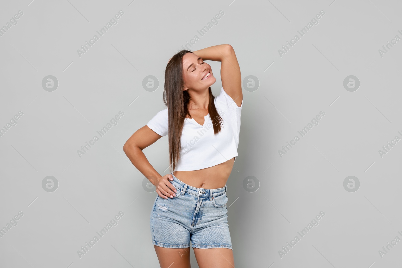 Photo of Beautiful woman wearing stylish denim shorts on gray background