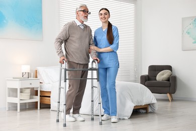 Photo of Nurse helping senior man with walking frame in clinic