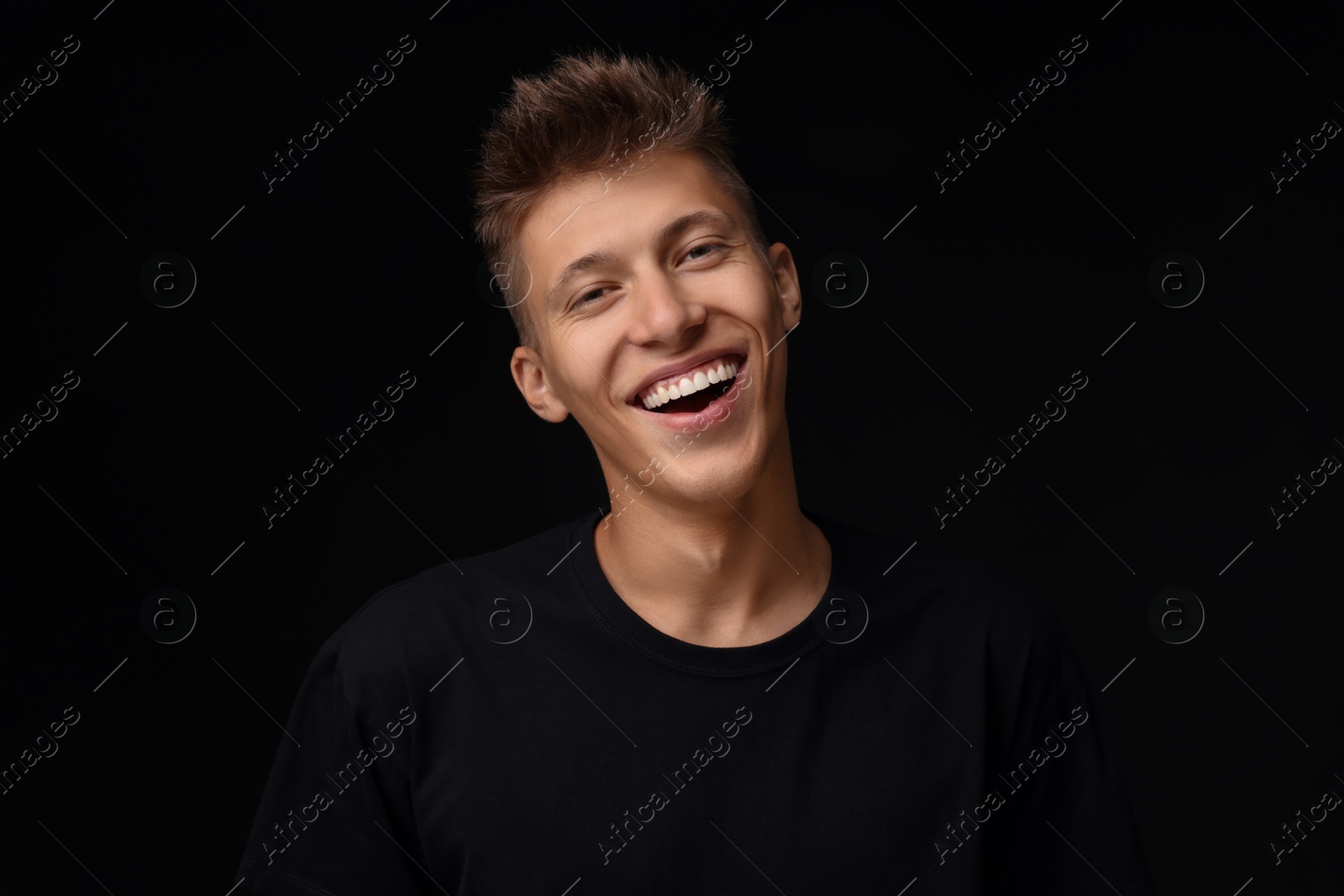 Photo of Portrait of happy young man on black background