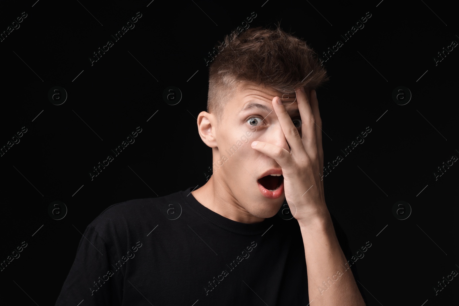 Photo of Portrait of scared young man on black background