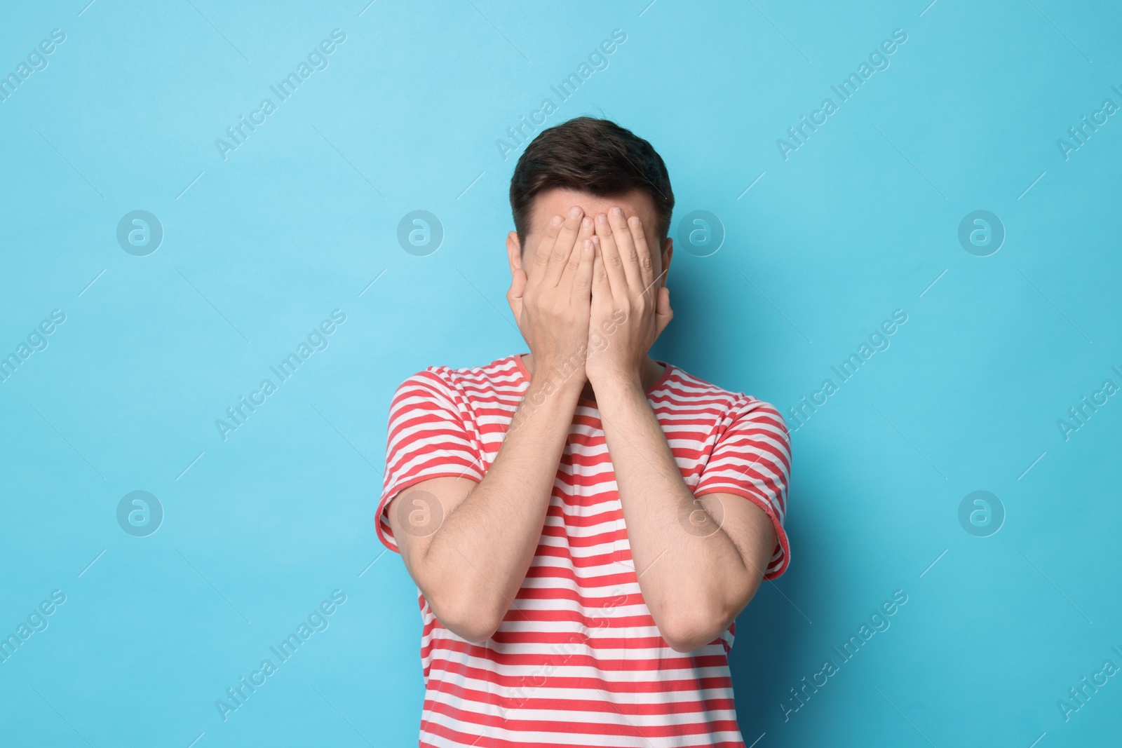 Photo of Portrait of scared young man on light blue background